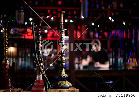 Barman fills black burnt ceramic bowl for hookah smoking different types of tobacco. Barman fills black burnt ceramic bowl for hookah smoking different types of tobacco. 76119856