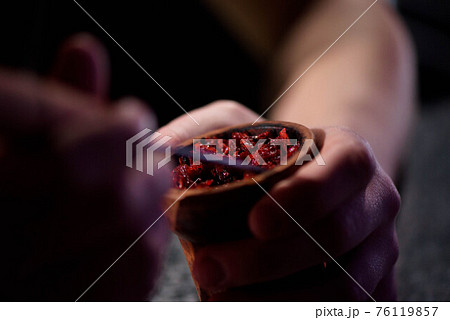 Barman fills black burnt ceramic bowl for hookah smoking different types of tobacco. 76119857