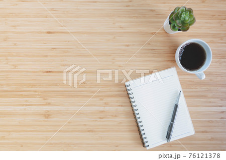 notebook with pencil , glasses, small tree and coffee on old wooden table.Top view. 76121378