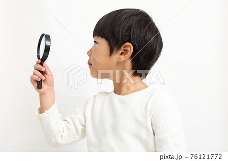 虫眼鏡で何かを調べる男の子 76121772