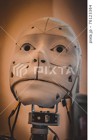 Face robot close-up. Face of an old robot made of white shabby plastic 76123364