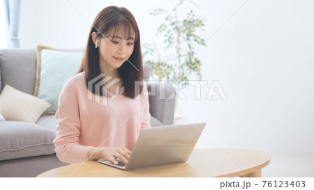 音声SNSを聞く女性 76123403