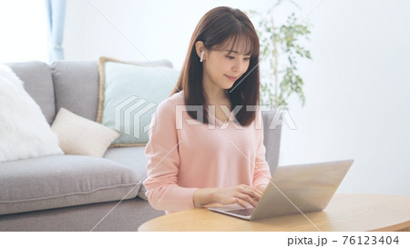 音声SNSを聞く女性 76123404