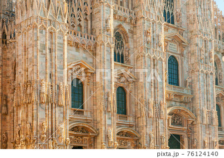 Famous church Milan Cathedral Duomo di Milano with Gothic spires and white marble statues. Top tourist attraction on piazza in Milan Lombardia Italy. Wide angle view of old Gothic architecture and art Famous church Milan Cathedral Duomo di Milano with Gothic spires and white marble statues. Top tourist attraction on piazza in Milan Lombardia Italy. Wide angle view of old Gothic architecture and art 76124140
