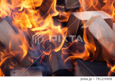 Burning firewood in the fireplace closeup, glowing logs, fire and flames Burning firewood in the fireplace closeup, glowing logs, fire and flames 76124906