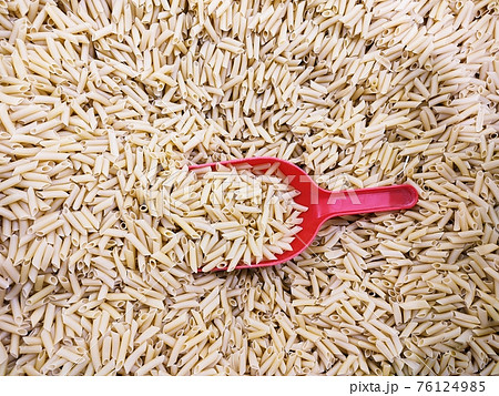 Dry raw italian penne pasta with scoop, whole wheat ingredient 76124985