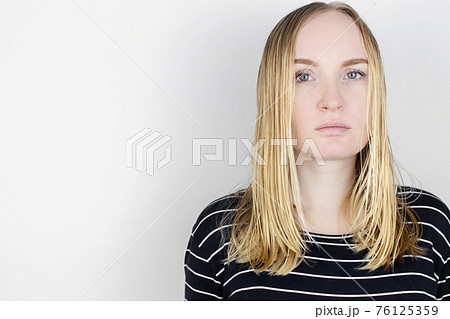 The girl looks in front of the mirror at her oily hair. Problematic scalp and increased secretion of the sebaceous glands. Hair care. Oily hair care and treatment concept The girl looks in front of the mirror at her oily hair. Problematic scalp and increased secretion of the sebaceous glands. Hair care. Oily hair care and treatment concept 76125359