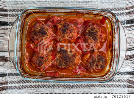 Meatballs baked in form in the oven with a gravy of tomato paste, tomatoes, onions and spices. Meatballs baked in form in the oven with a gravy of tomato paste, tomatoes, onions and spices. 76125617