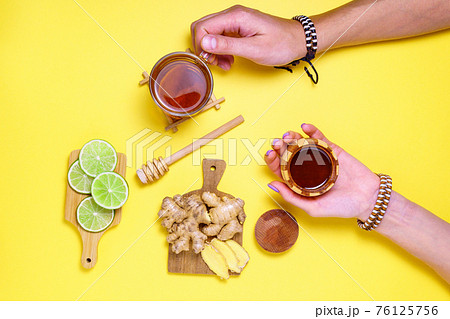 Lime, ginger, Honey Cup of Herbal Tea. Flat Lay, CopySpace. Alternative cold and flu remedy. Healthy Food. on yellow background Lime, ginger, Honey Cup of Herbal Tea. Flat Lay, CopySpace. Alternative cold and flu remedy. Healthy Food. on yellow background 76125756