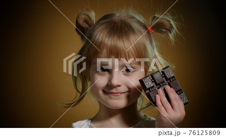 Child kid girl with chocolate bar showing ok gesture sign, satisfied teen girl making faces, smiling 76125809