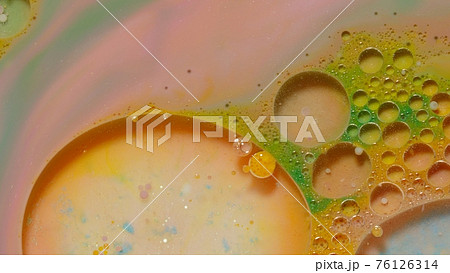 Ink bubbles mixed with liquid substance of oil, milk, soap, bright acrylic paint on colorful surface 76126314