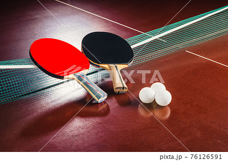 table tennis rackets on the net and balls 76126591