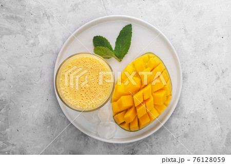 Lassi is a popular traditional yogurt based cold drink with mango in India, top vew Lassi is a popular traditional yogurt based cold drink with mango in India, top vew 76128059