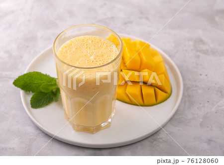 Lassi is a popular traditional yogurt based cold drink with mango in India, close up Lassi is a popular traditional yogurt based cold drink with mango in India, close up 76128060