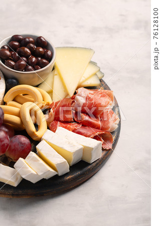 Charcuterie board with spanish jamon, brie cheese and berries Charcuterie board with spanish jamon, brie cheese and berries 76128100