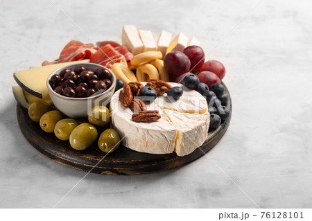 Charcuterie board with spanish jamon, pork sausage with pepper, fuet, cheese and berries Charcuterie board with spanish jamon, pork sausage with pepper, fuet, cheese and berries 76128101
