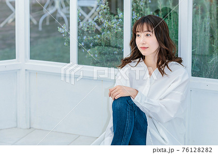 明るいテラスに座る若い女性 明るいテラスに座る若い女性 76128282