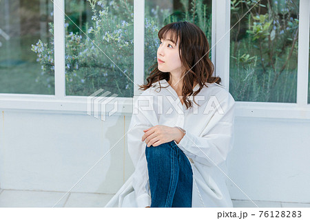 明るいテラスに座る若い女性 明るいテラスに座る若い女性 76128283