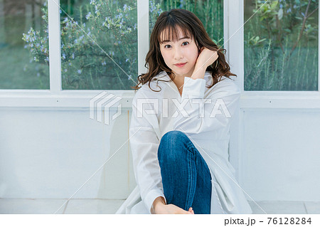 明るいテラスに座る若い女性 明るいテラスに座る若い女性 76128284