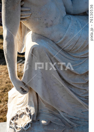 Close up of crown of thorns and Christ's arm in stone pieta statue 76130536
