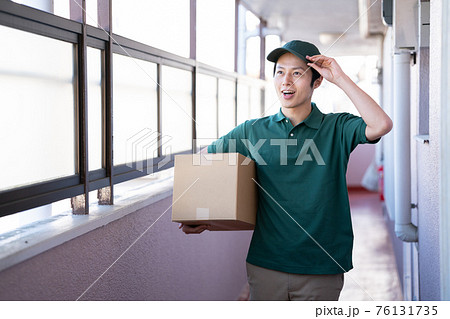 荷物を届ける宅急便の男性 荷物を届ける宅急便の男性 76131735