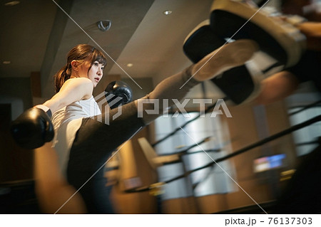 パーソナルトレーナーにキックボクシングを習うアジア人女性 パーソナルトレーナーにキックボクシングを習うアジア人女性 76137303