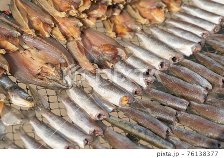 Row of traditional salted fresh fish drying in local market. Fresh food for cooking or sale. Fishery industry. Dead animal. Row of traditional salted fresh fish drying in local market. Fresh food for cooking or sale. Fishery industry. Dead animal. 76138377