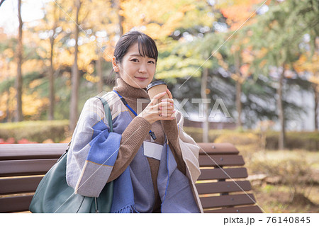 秋の公園でコーヒーを飲む会社員の女性(笑顔) 秋の公園でコーヒーを飲む会社員の女性(笑顔) 76140845
