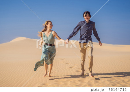 Happy couple healthy lifestyle affectionate outdoors in nature during hiking travel. Man and woman hikers smiling in mountain desert landscape. Tourism opens after quarantine COVID 19 76144712