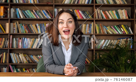 Successful businesswoman raises hands in happiness at table 76146087
