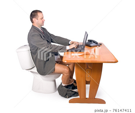 man sitting on the toilet in office 76147411
