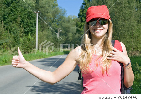 girl with rucksack stops the car girl with rucksack stops the car 76147446