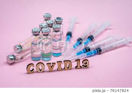 Medical ampoules and syringes on a pink background. Vaccination against covid-19. Medical ampoules and syringes on a pink background. Vaccination against covid-19. 76147824