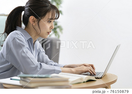 パソコンに入力する若い女性の横顔 76150879