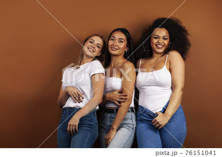young pretty asian, caucasian, afro woman posing cheerful together on brown background, lifestyle diverse nationality people concept young pretty asian, caucasian, afro woman posing cheerful together on brown background, lifestyle diverse nationality people concept 76151041