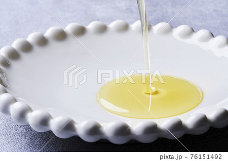 白い皿に注がれるオリーブオイル 76151492