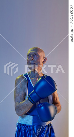 Senior man wearing sportwear boxing isolated on gradient studio background in neon light. Concept of sport, activity, movement, wellbeing. Copyspace, ad. Senior man wearing sportwear boxing isolated on gradient studio background in neon light. Concept of sport, activity, movement, wellbeing. Copyspace, ad. 76153007