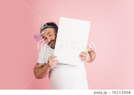 Handsome caucasian plus size male model isolated on coral pink studio background. Concept of inclusion, human emotions, facial expression 76153008