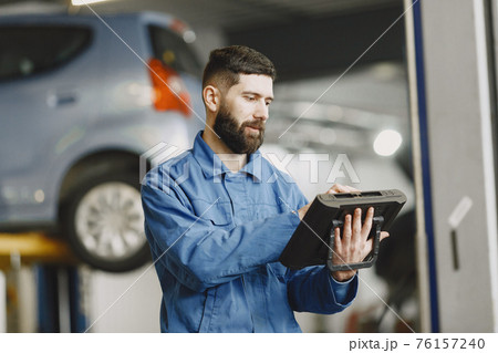 ar mechanic with a tablet near car in work clothes ar mechanic with a tablet near car in work clothes 76157240