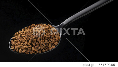 Instant granulated coffee on black background 76159386