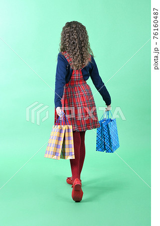 Child with a packaging checkered texture isolated on white background. Girl likes shopping on sale season. Holiday present, shopping. Child with a packaging checkered texture isolated on white background. Girl likes shopping on sale season. Holiday present, shopping. 76160487