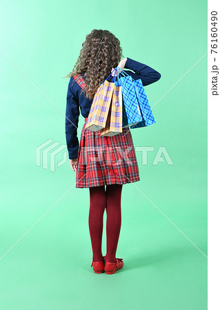 Child with a packaging checkered texture isolated on white background. Girl likes shopping on sale season. Holiday present, shopping. 76160490