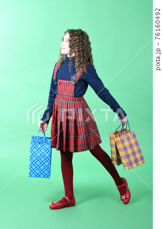 Child with a packaging checkered texture isolated on white background. Girl likes shopping on sale season. Holiday present, shopping. Child with a packaging checkered texture isolated on white background. Girl likes shopping on sale season. Holiday present, shopping. 76160492