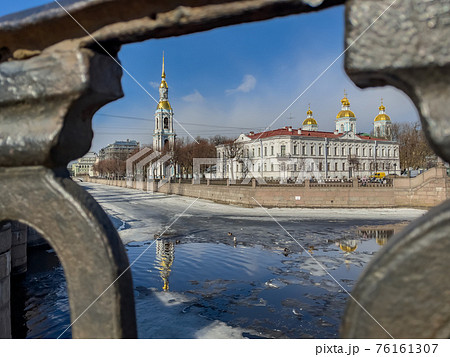 St. Nicholas Naval Cathedral belltower through the forged lattice in a clear sunny day of spring, an ice drift on Kryukov and Griboyedov Canal, a view of seven bridges from the embankment St. Nicholas Naval Cathedral belltower through the forged lattice in a clear sunny day of spring, an ice drift on Kryukov and Griboyedov Canal, a view of seven bridges from the embankment 76161307