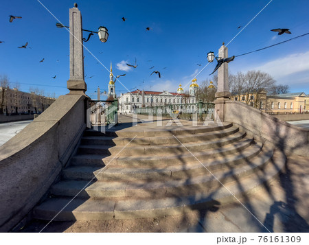 Russia, St. Petersburg, 01 April 2021: St. Nicholas Naval Cathedral belltower in a clear sunny day of spring, an ice drift on Kryukov and Griboyedov Canal, a view of seven bridges from the embankment Russia, St. Petersburg, 01 April 2021: St. Nicholas Naval Cathedral belltower in a clear sunny day of spring, an ice drift on Kryukov and Griboyedov Canal, a view of seven bridges from the embankment 76161309
