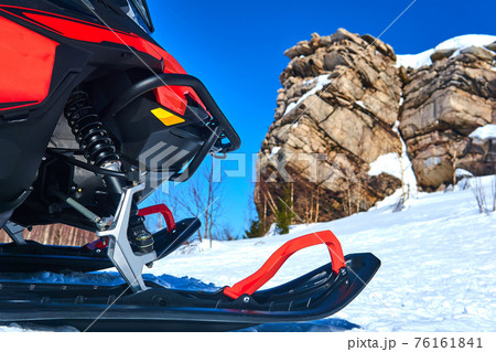 snowmobile in the foreground against a blurred mountain winter landscape snowmobile in the foreground against a blurred mountain winter landscape 76161841