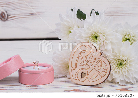 Wedding ring in box and white flowers. Wedding ring in box and white flowers. 76163507