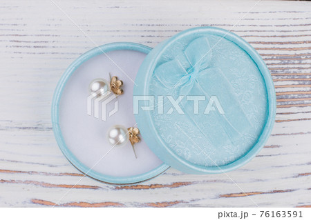 Open gift box with pearl earrings. Open gift box with pearl earrings. 76163591