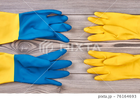 Colorful rubber gloves on wooden background. Colorful rubber gloves on wooden background. 76164693