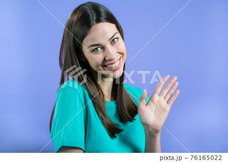Friendly woman waving hand - goodbye, chao, adios. Parting, say bye to camera. Beautiful girl waving 76165022